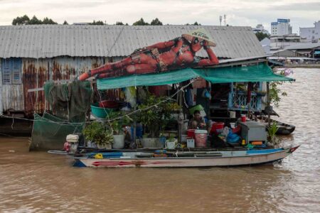 A floating house uses promotional images from the upcoming Deadpool movie to temporarily reinforce its roof in Can Tho city, Vietnam. September, 2024.