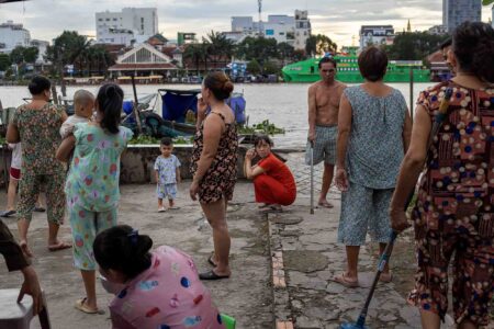 Residents of Ninh Kieu fishing village are chilling on the river bank. They will soon have to move to a new settlement.